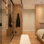Built-in modern bedroom wardrobe in warm wood with minimalist storage design