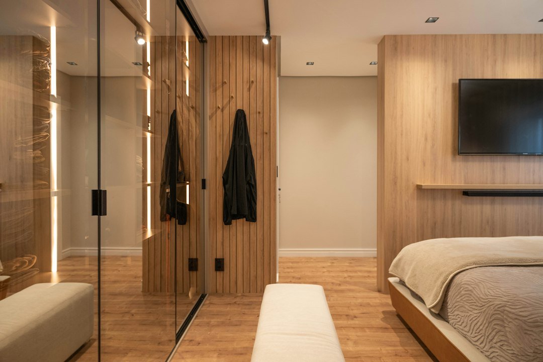 Built-in modern bedroom wardrobe in warm wood with minimalist storage design